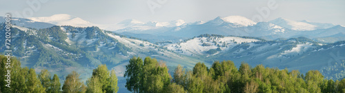 Snow in the mountains in early spring, panoramic view photo