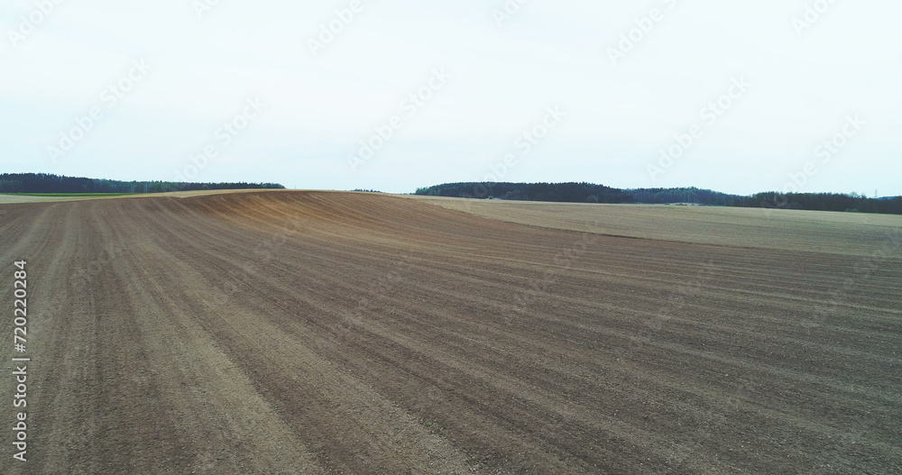 Aerial of tractor harvesting field.