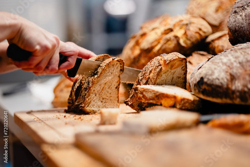 Frisches Brot wird von Bäckerin geschnitten