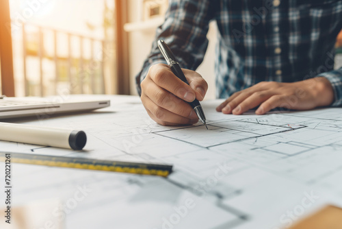 Architect or engineer working on blueprint at office desk, Construction concept