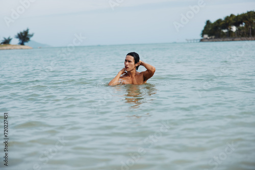 Blue Summer Splash: Active Man Enjoying Tropical Beach Vacation Swimming in the Ocean