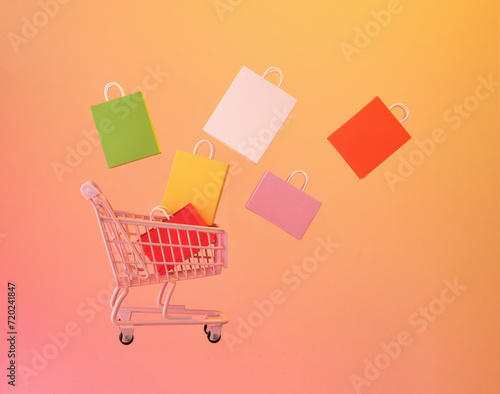Consumer society trend. Shopping cart and colorful bags.