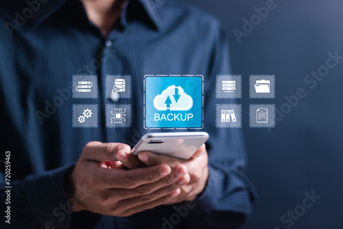 Backup storage data technology concept. Person use smartphone with virtual backup icons for backup online documentation database and digital file storage system or software,file access, doc sharing.