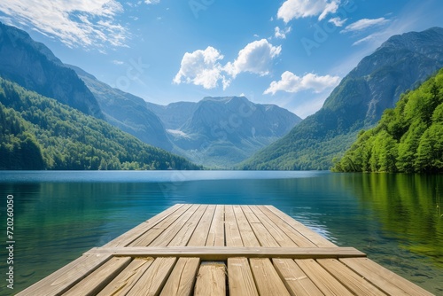 A wooden pier on a mountain lake on a bright sunny day © DK_2020