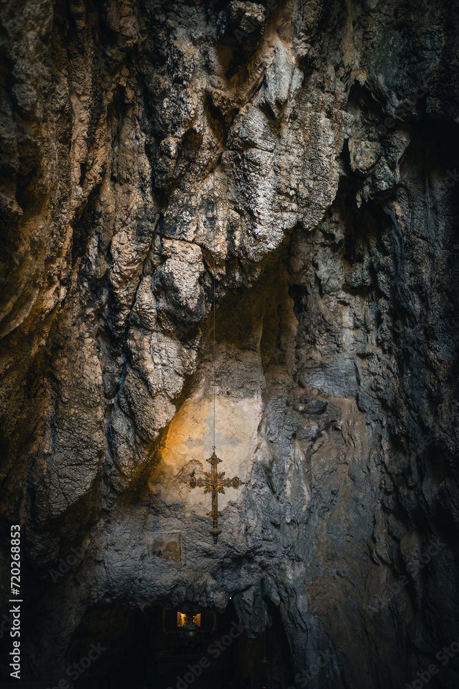 crucifix hanging in a shrine in a cave