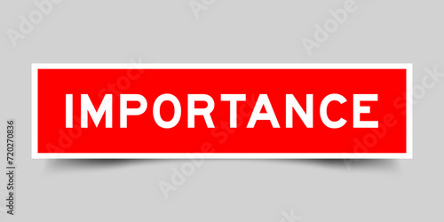 Red color square shape sticker label with word importance on gray background