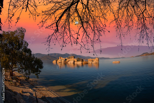 Different views of Bafa Lake in Aegean province of Turkey, boats pier island with monastery and rock forms on a colorful sunset and reflections photo