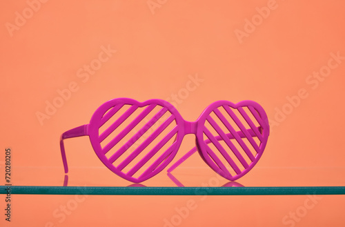 Pink glasses in the shape of hearts. Fashionable women's accessory.