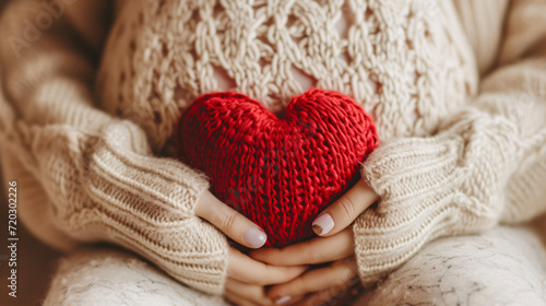 Pregnant woman holding knitted heart