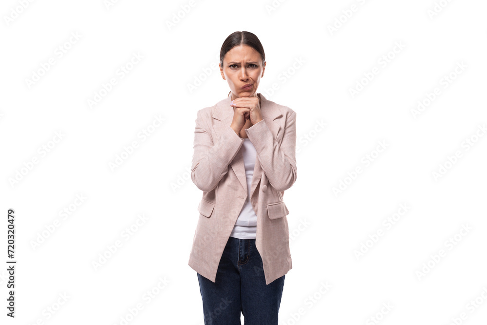 young smart well-groomed brunette woman dressed in a beige jacket thought on a white background with copy space young smart well-groomed brunette woman dressed in a beige jacket thought on a white background with copy space