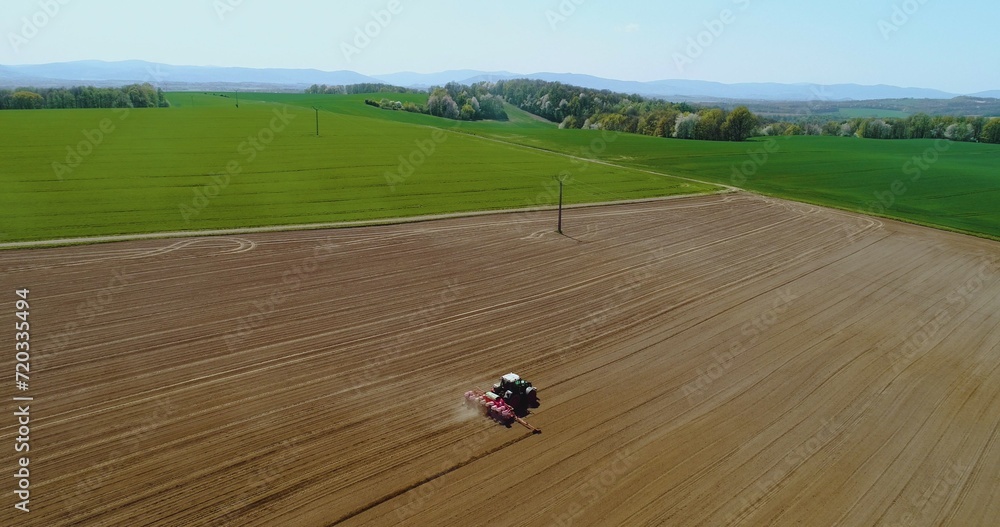 Tractor working in beautiful spacious agricultural field