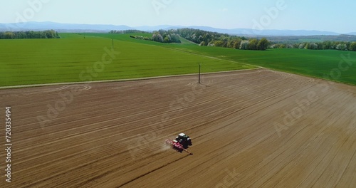 Tractor working in beautiful spacious agricultural field