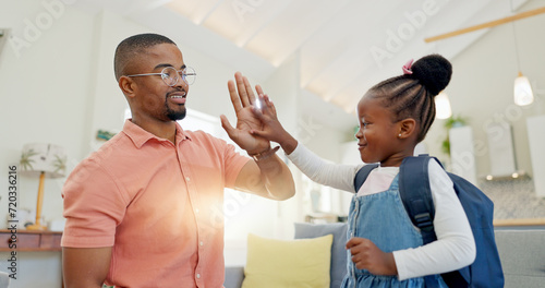 Black family, education and girl with backpack for school, kindergarten and high five from dad for support and motivation. Child, student and father helping to get ready and leave house in morning photo