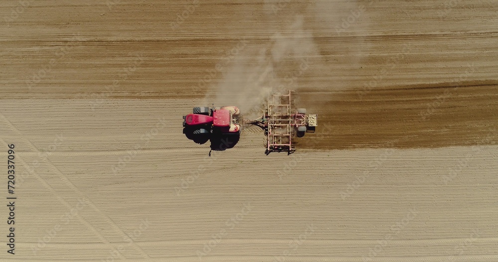 Aerial of tractor on harvest field ploughing agricultural field.
