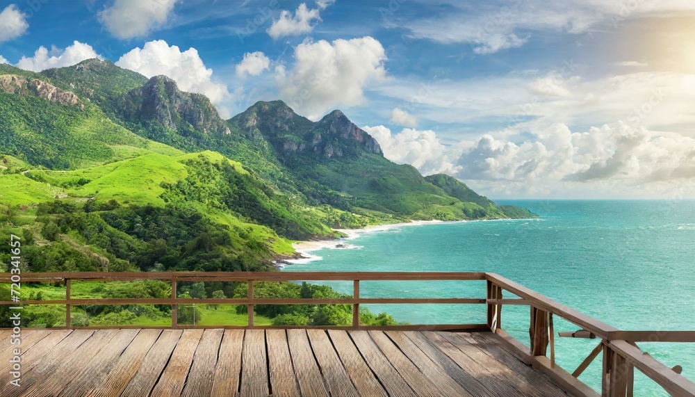 wide view of green mountainous beach in front of sea in summer, cloudy sky, with wooden terrace