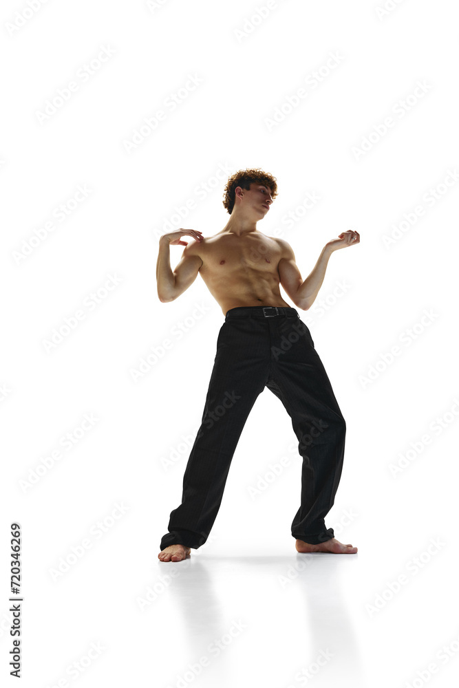 Obraz premium Freeze movement. Young male choreographer with naked torso dancing in motion against white studio background. Concept of art, human motions, wellness, natural beauty of male body. Ad