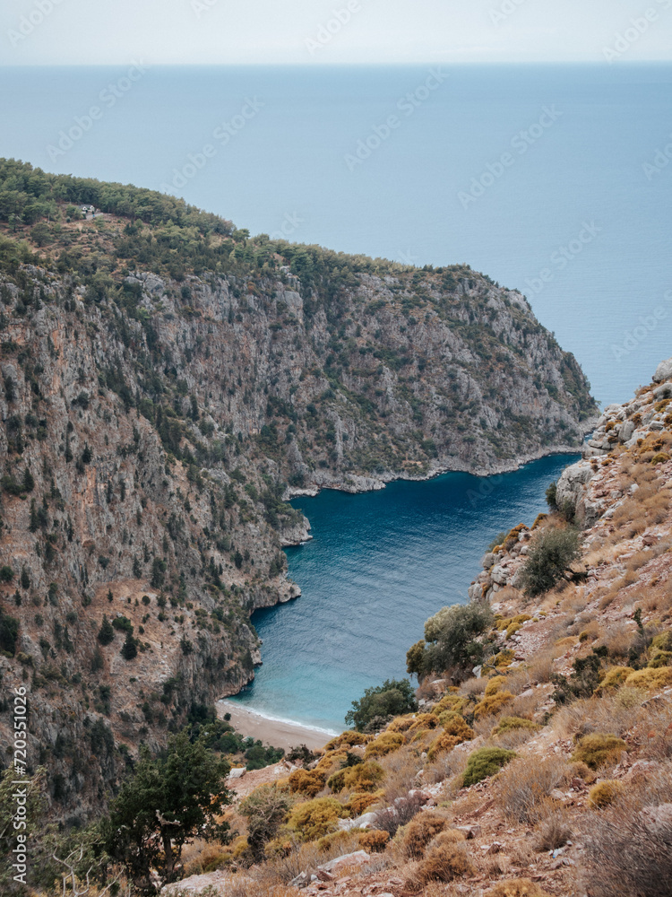 view of the blue water of a bay in the mediterranean sea on the coast of turkey. rocky coast with green plants