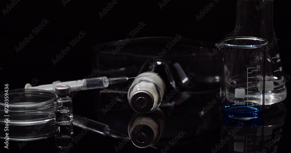 Laboratory Equipement: Syringe and Medicine, Test Tubes and Flasks Rotating on Black Background. Laboratory Equipement: Syringe and Medicine, Test Tubes and Flasks Rotating on Black Background.