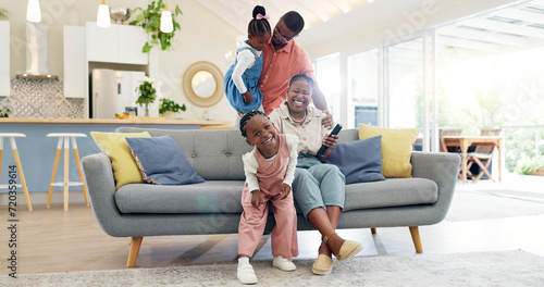 Happiness, playful parents and kids on sofa, black family having fun and smile in home together. Mother, father and young children playing on couch in living room, happy playing with love and support