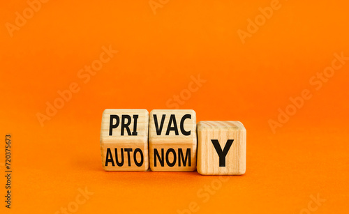Privacy or autonomy symbol. Concept word Privacy or Autonomy on wooden cubes. Beautiful orange table orange background. Business privacy or autonomy concept. Copy space.
