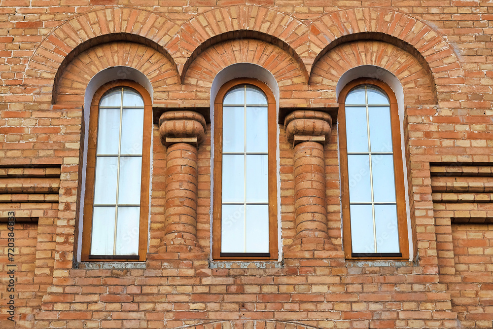 Fragment of a historical building with 3 side-by-side vertical windows Fragment of a historical building with 3 side-by-side vertical windows