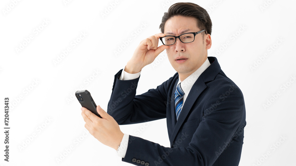 スマートフォンを見て驚く男性 スマートフォンを見て驚く男性