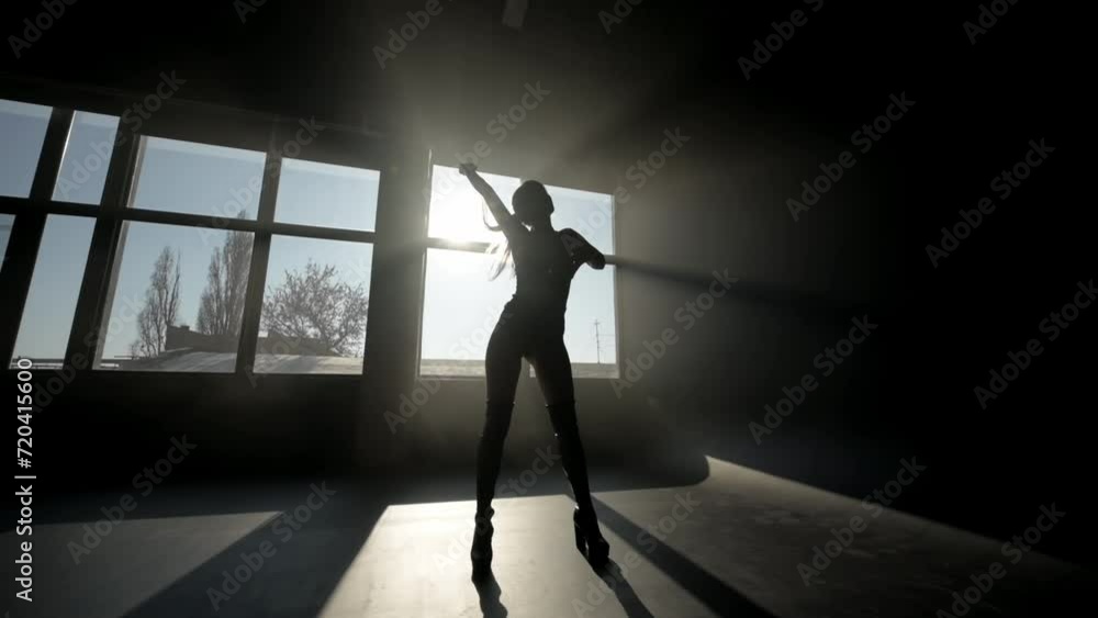 silhouette of a girl in a black latex outfit. Girl in silhouette against the background of a window silhouette of a girl in a black latex outfit. Girl in silhouette against the background of a window