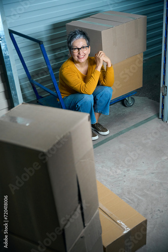 Lady sitting near cardboard boxes looking at camera