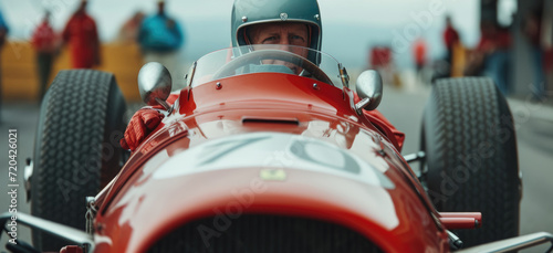 Driver driving a classic vintage racing car on a sports track.