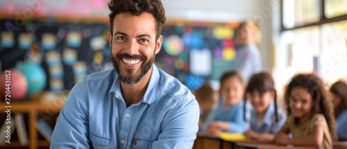Happy male elementary school teacher. Students are in classroom behind him in a blurry background. Fun and enjoyable learning, love for education concept. photo