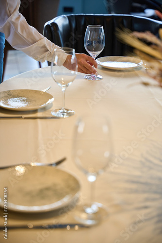 Waitress in white jacket serves a table in restaurant hall