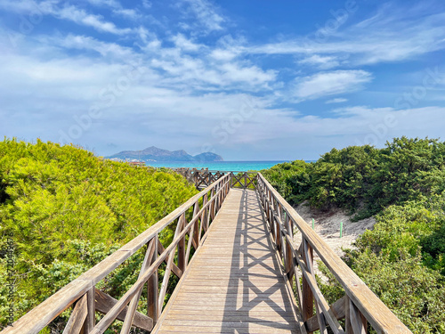 Way to the beach through a pine forest along a wooden path in Mallorca