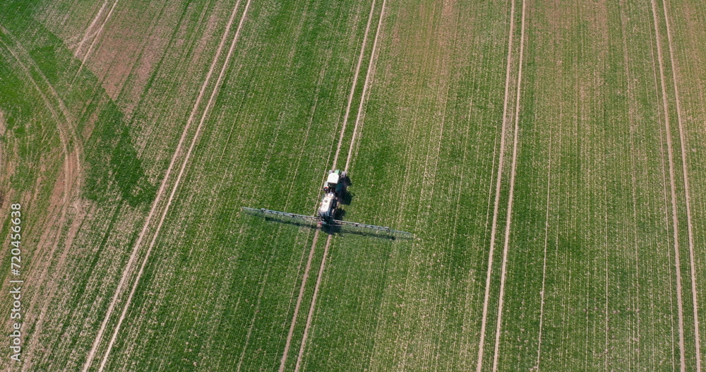 Tractor Spraying Pesticides on Wheat Field Tractor Spraying Pesticides on Wheat Field