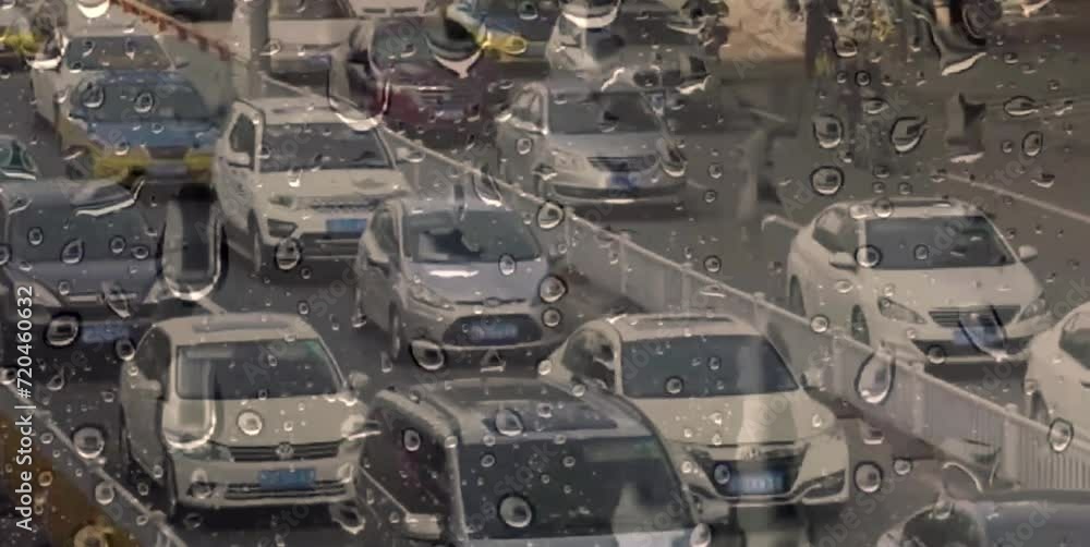 the atmosphere and condition of the road with passing vehicles seen from behind glass that is wet from rain the atmosphere and condition of the road with passing vehicles seen from behind glass that is wet from rain