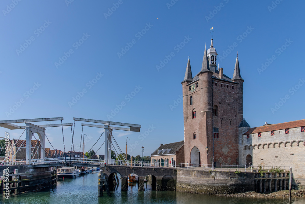 Harbor waters in Zierikzee, the Netherlands with drawbridge leading from the Zuidhavenpoort entrace to the city to the Noordhavenpoort against a clear blue sky
