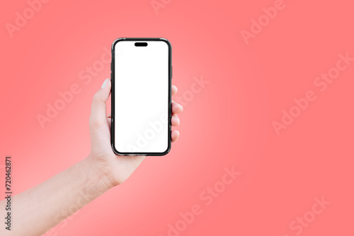 Close-up of male hand holding smartphone with blank on screen isolated on colourful background of red colour. Mockup concept. photo