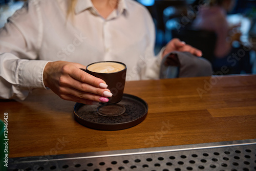 Waitress holds a cup of coffee in her hands