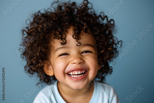 toddler with curly hair laughing