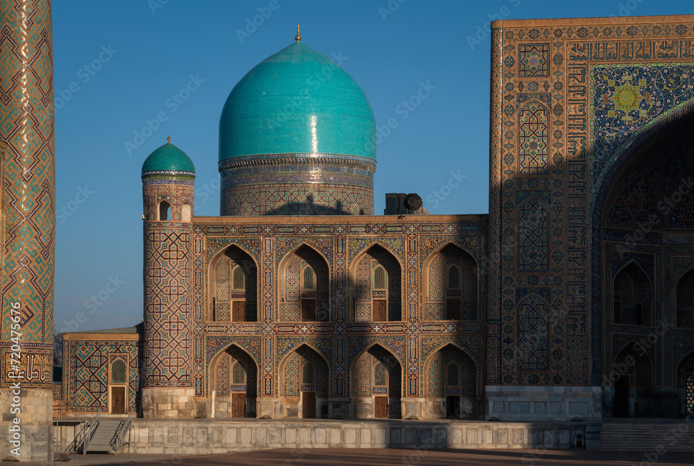 View of Tillya-Kari Madrasah and domed mosque building in the northern part of Registan Square on a sunny day, Samarkand, Uzbekistan