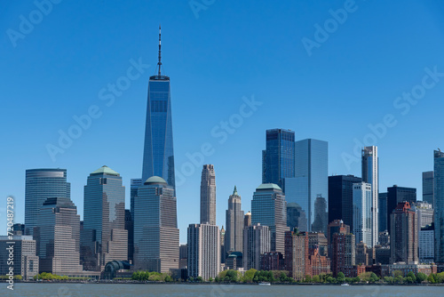 Panoramic view of skyscrapers on the waterfront of lower Manhattan, New York City, NY, USA seen from the Hudson river side against a clear blue sky