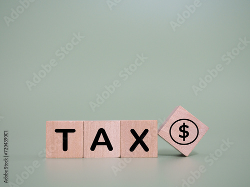 Wooden blocks with the word TAX and dollar coin icons. The concept about saving money and manage time to paying tax