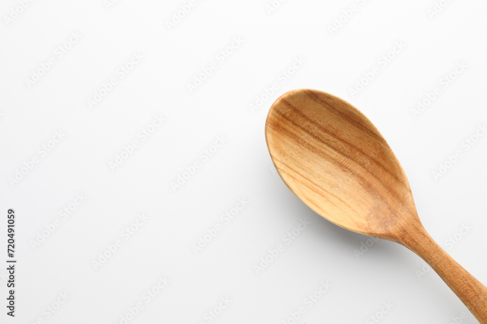 One wooden spoon on white background, top view. Space for text One wooden spoon on white background, top view. Space for text