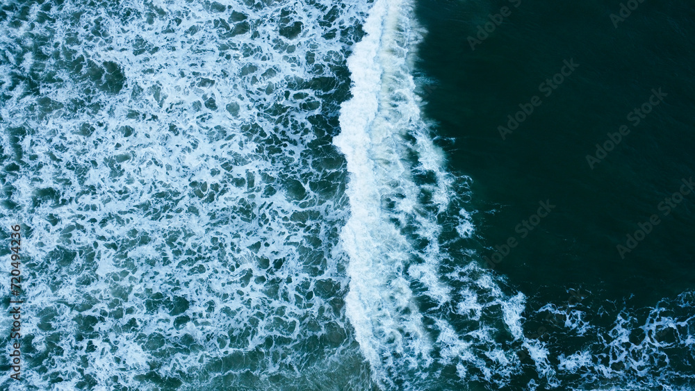 Overhead view to blue stormy ocean waves with white foam. Overhead view to blue stormy ocean waves with white foam.