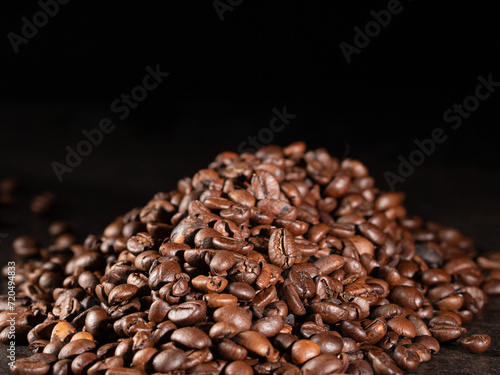 Rustic style roasted coffee beans on dark background - low key photography