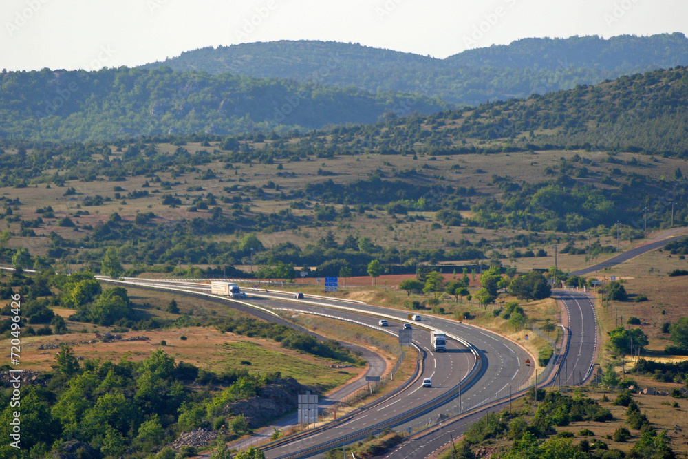 Fototapeta premium Autoroute A75, causse du Larzac, et collines calcaires vers le pas de l'Escalette, réseau routier, infrastructures autoroutières, Hérault, Languedoc Roussillon Sud de la France
