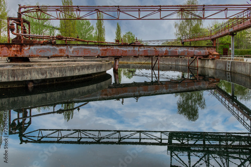 Low angle view of an abandoned and dilapidated water purification basin of an industrial steel mill in public Landschaftspark, Duisburg, Germany