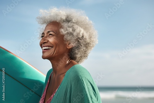 Side view, a happy 79-year-old black woman, with surfboard, at beach, teal clothes , in a commercial photography style