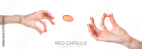 Hand holding a red capsule isolated on white background. Red pill isolated.