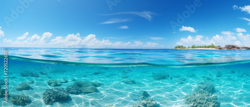 Split-View Tropical Seascape. Crystal clear waters with coral reefs below and a sunny sky above