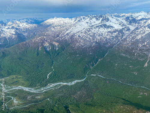 Lake Clark National Park and Preserve in Alaska. Braided alpine rivers full of snowmelt. Aerial view over rugged and remote mountains. 